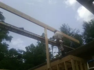 Carpenter setting a ridge beam over a new addition frame — Ice Dam Removal by Roofing Brothers in Solen