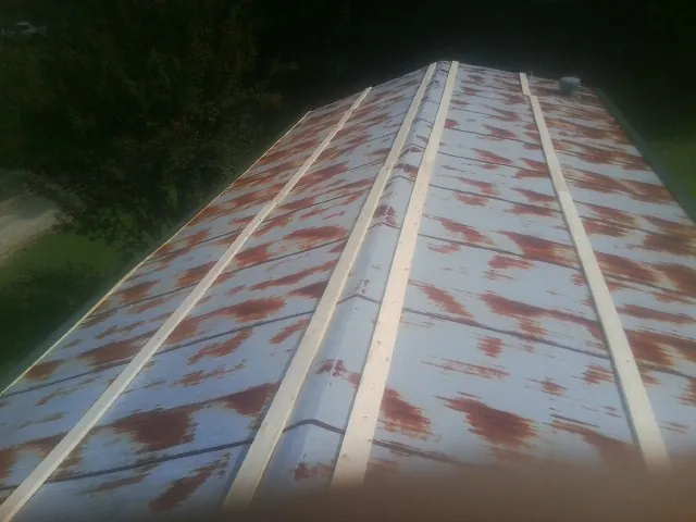 Rusted metal roof panels with new wood purlins before replacement — Storm Damage Roof Repair in Solen by Roofing Brothers