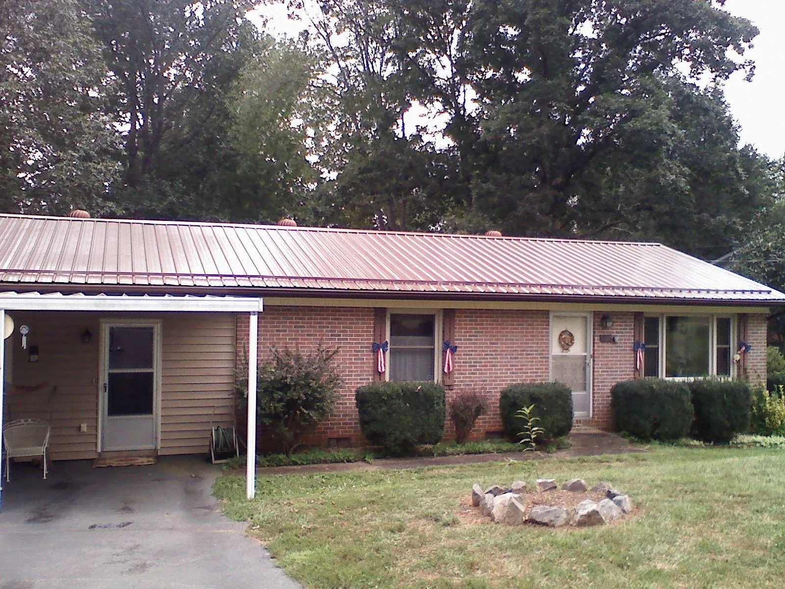 Bronze metal roof and carport on a brick ranch home — Roof Repair work by our crew in Solen